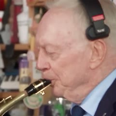 The saxophone player in the navy suit in the example video
